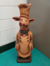 Cheeky wooden statue of a cooking pig
